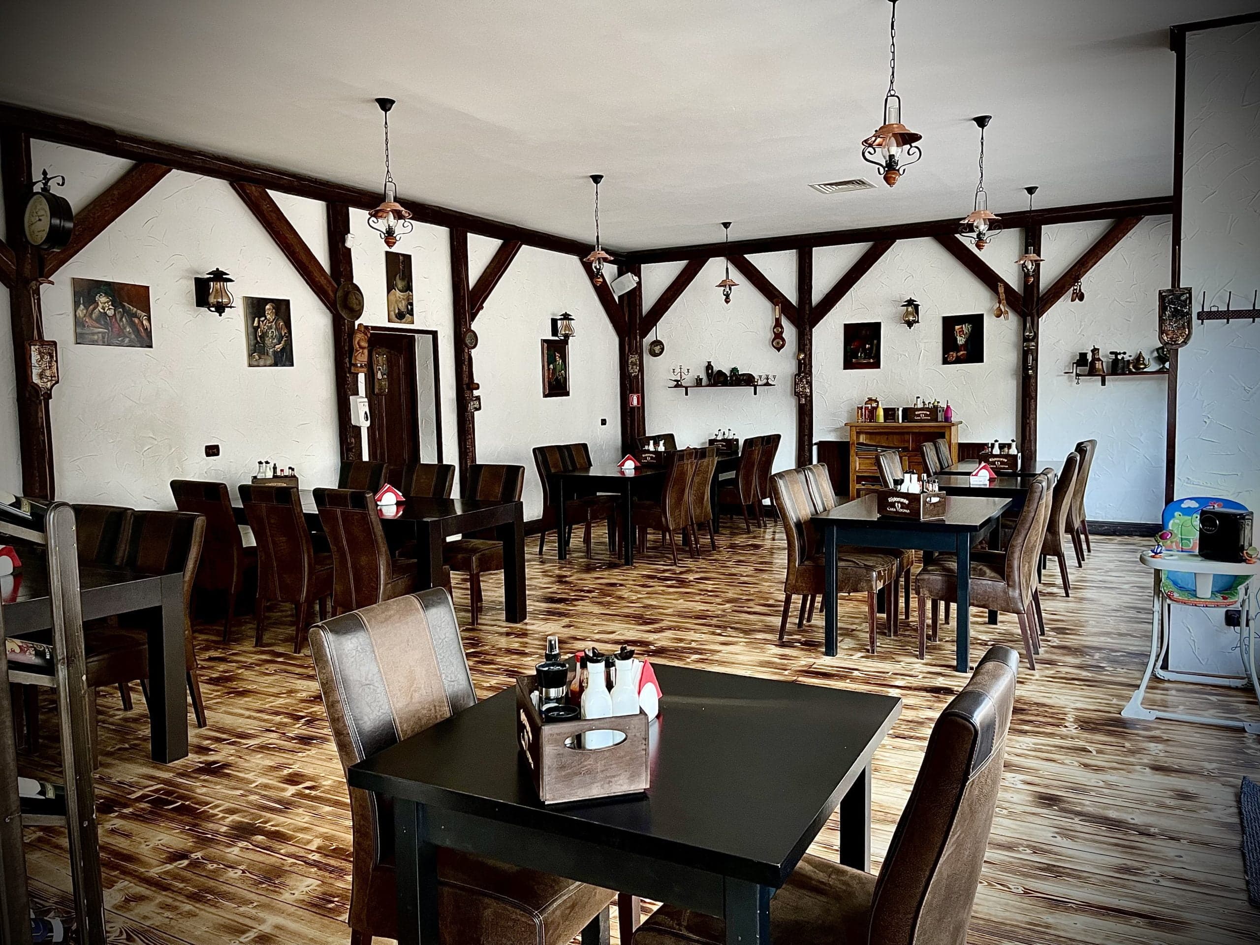 Salonul rustic Casa Verona cu grinzi de lemn și mese din lemn închis
